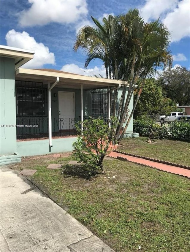 791 E 22nd St, Hialeah, FL 33013 - view of side of home with a yard and a porch