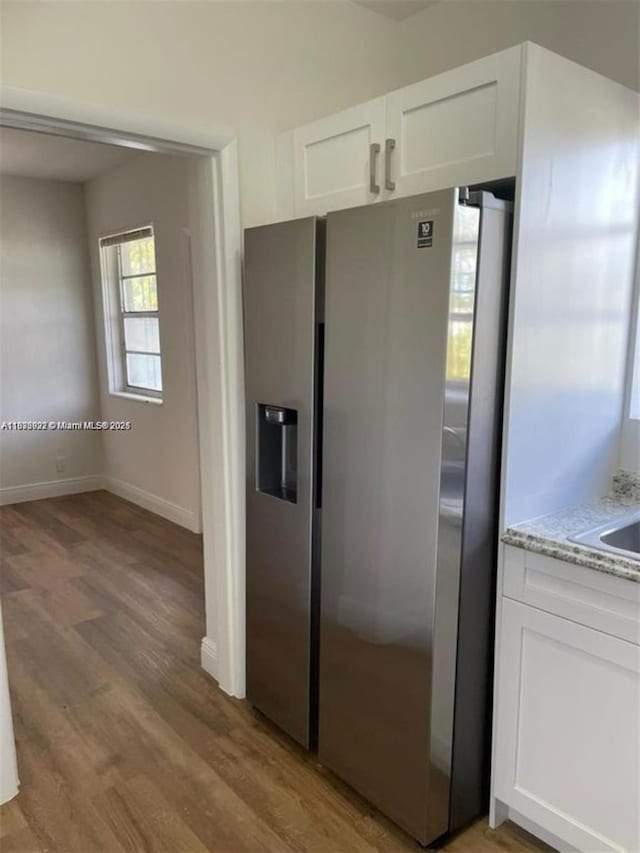 791 E 22nd St, Hialeah, FL 33013 - kitchen with stainless steel refrigerator with ice dispenser, light stone counters, white cabinetry, and light wood-type flooring