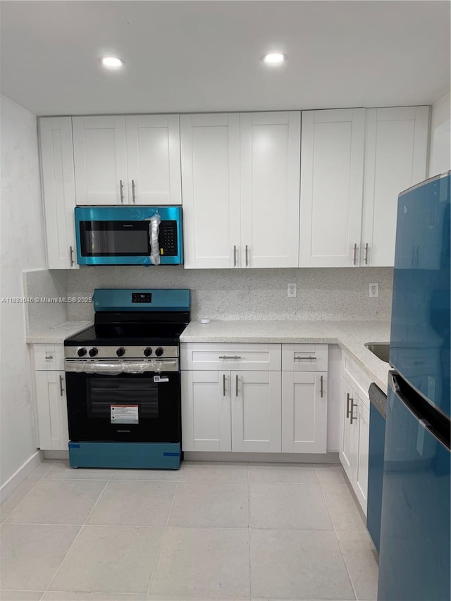 7915 Camino Real Unit N-302, Miami, FL 33143 - kitchen featuring stainless steel appliances, light countertops, white cabinetry, and recessed lighting