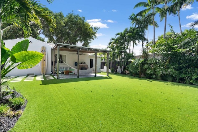 631 NE 87th St, Miami, FL 33138 - back of house with a ceiling fan, a patio area, a yard, and stucco siding