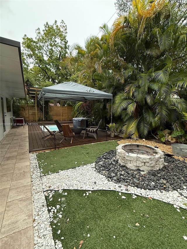 5838 Madison St, Hollywood, FL 33023 - fenced yard featuring a fire pit, a gazebo, a wooden deck, and a patio