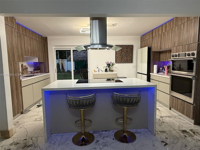 5838 Madison St, Hollywood, FL 33023 - kitchen with island range hood, modern cabinets, stainless steel double oven, and light marble finish floors