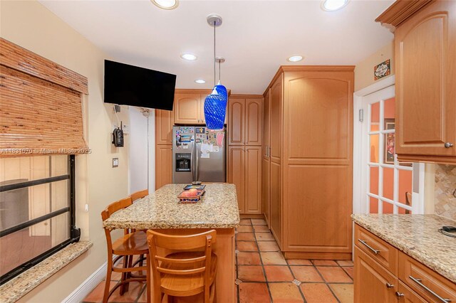 8445 SW 80th Pl, Miami, FL 33143 - kitchen featuring stainless steel fridge, recessed lighting, light stone countertops, a breakfast bar area, and hanging light fixtures