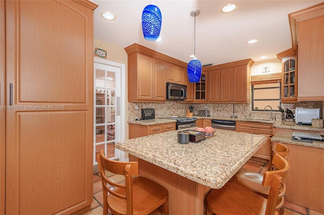 8445 SW 80th Pl, Miami, FL 33143 - kitchen with stainless steel appliances, a breakfast bar area, tasteful backsplash, a center island, and light stone countertops