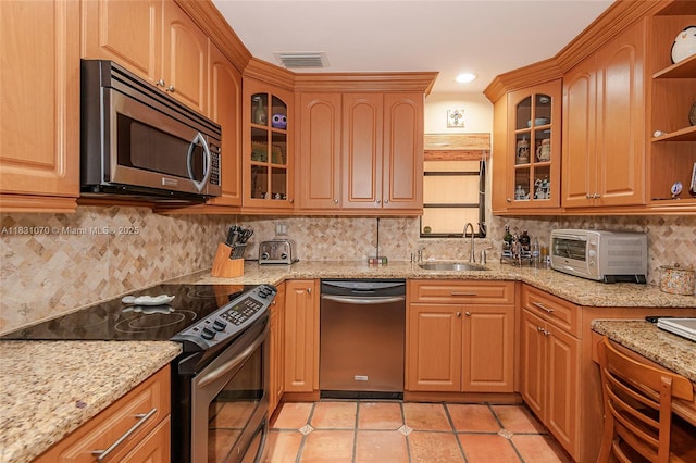 8445 SW 80th Pl, Miami, FL 33143 - kitchen featuring appliances with stainless steel finishes, open shelves, light stone countertops, light tile patterned floors, and tasteful backsplash