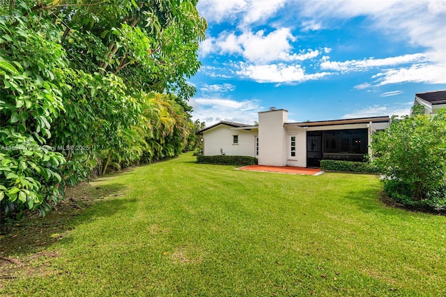 8445 SW 80th Pl, Miami, FL 33143 - view of green lawn with a patio area and a sunroom