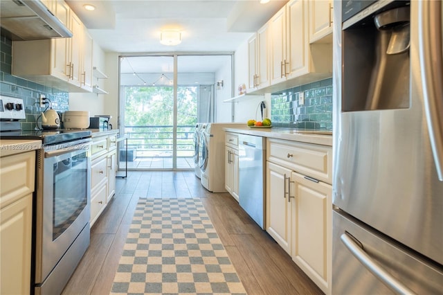kitchen with stainless steel appliances, under cabinet range hood, backsplash, light wood finished floors, and recessed lighting