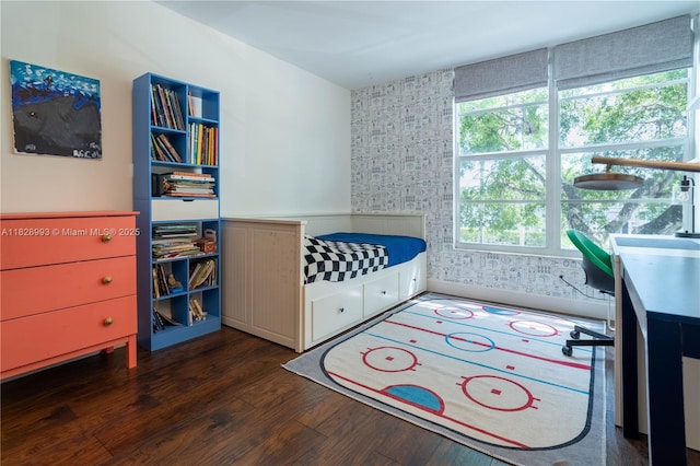 bedroom featuring wood finished floors and wallpapered walls