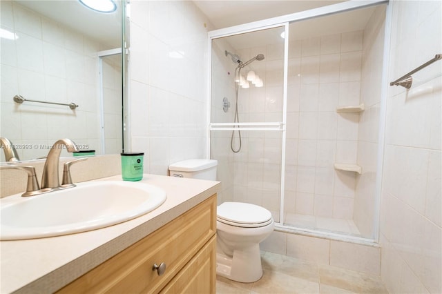 bathroom featuring tile walls, vanity, a shower stall, and tile patterned flooring