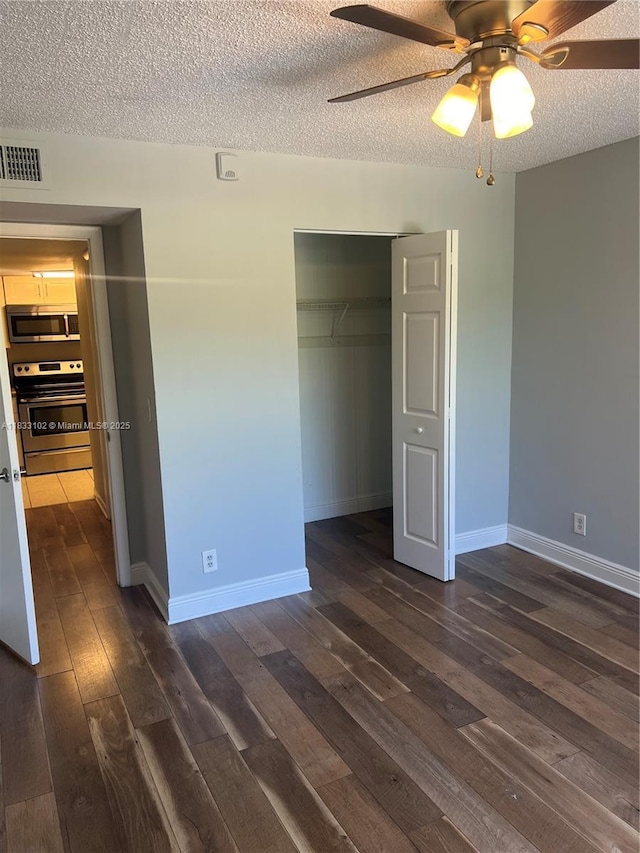 10725 Cleary Blvd Unit 205, Plantation, FL 33324 - unfurnished bedroom with a textured ceiling, dark wood finished floors, a closet, and ceiling fan