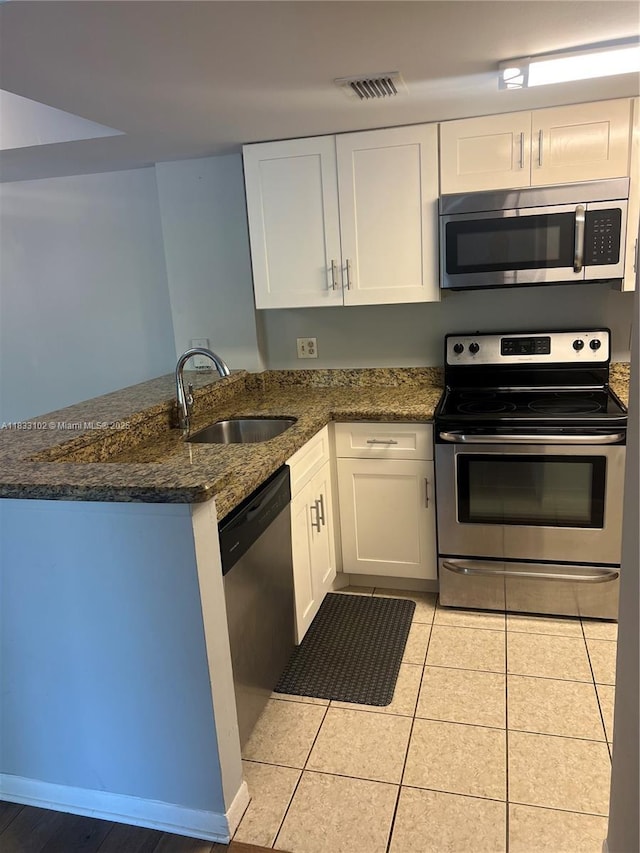 10725 Cleary Blvd Unit 205, Plantation, FL 33324 - kitchen featuring stainless steel appliances, a peninsula, white cabinetry, and dark stone countertops