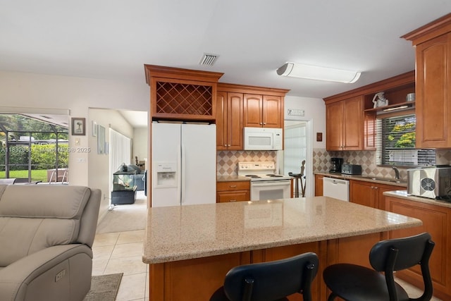 15471 SW 83rd Ave, Palmetto Bay, FL 33157 - kitchen with white appliances, open floor plan, light stone countertops, a breakfast bar, and backsplash