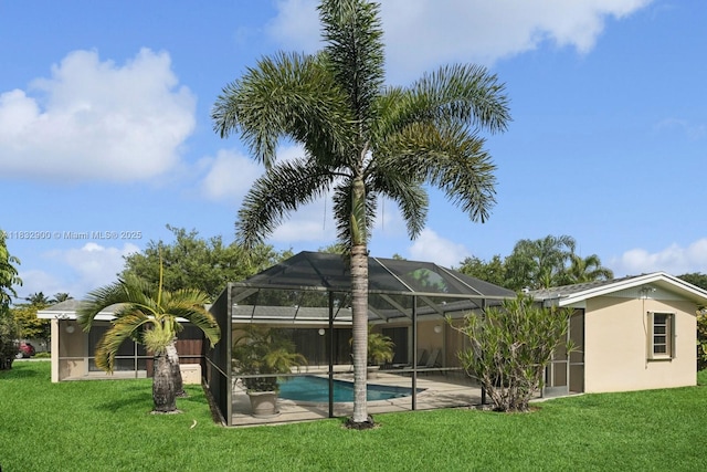15471 SW 83rd Ave, Palmetto Bay, FL 33157 - back of house featuring a lawn, an outdoor pool, stucco siding, and a patio