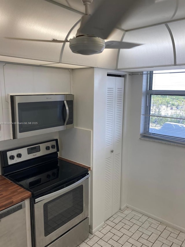 3703 NE 166th St Unit 905, North Miami Beach, FL 33160 - kitchen featuring appliances with stainless steel finishes, wood counters, and brick patterned flooring