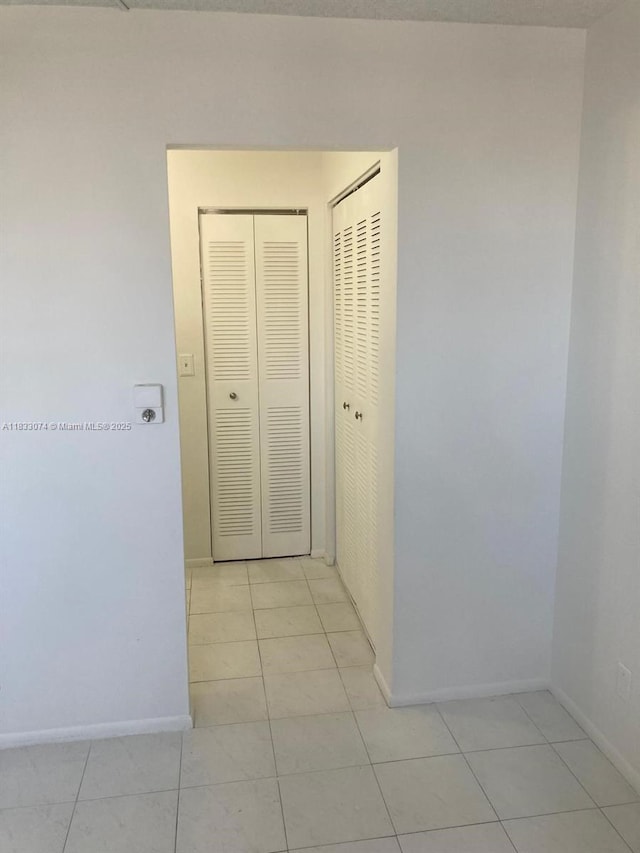 3703 NE 166th St Unit 905, North Miami Beach, FL 33160 - hallway featuring light tile patterned flooring and baseboards