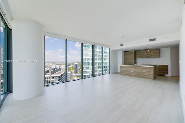 650 NE 32nd St Unit 4301, Miami, FL 33137 - unfurnished living room with a wall of windows, plenty of natural light, light wood-style flooring, and a view of city