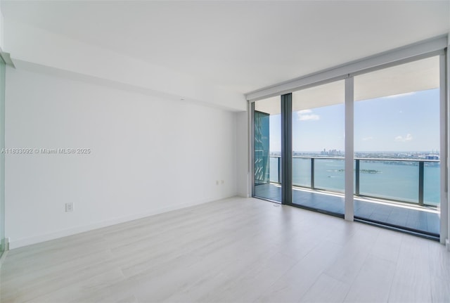 650 NE 32nd St Unit 4301, Miami, FL 33137 - unfurnished room featuring floor to ceiling windows, wood finished floors, and a water view