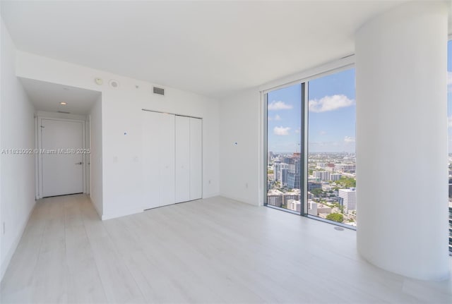 650 NE 32nd St Unit 4301, Miami, FL 33137 - unfurnished bedroom featuring expansive windows, light wood-type flooring, a closet, and a city view