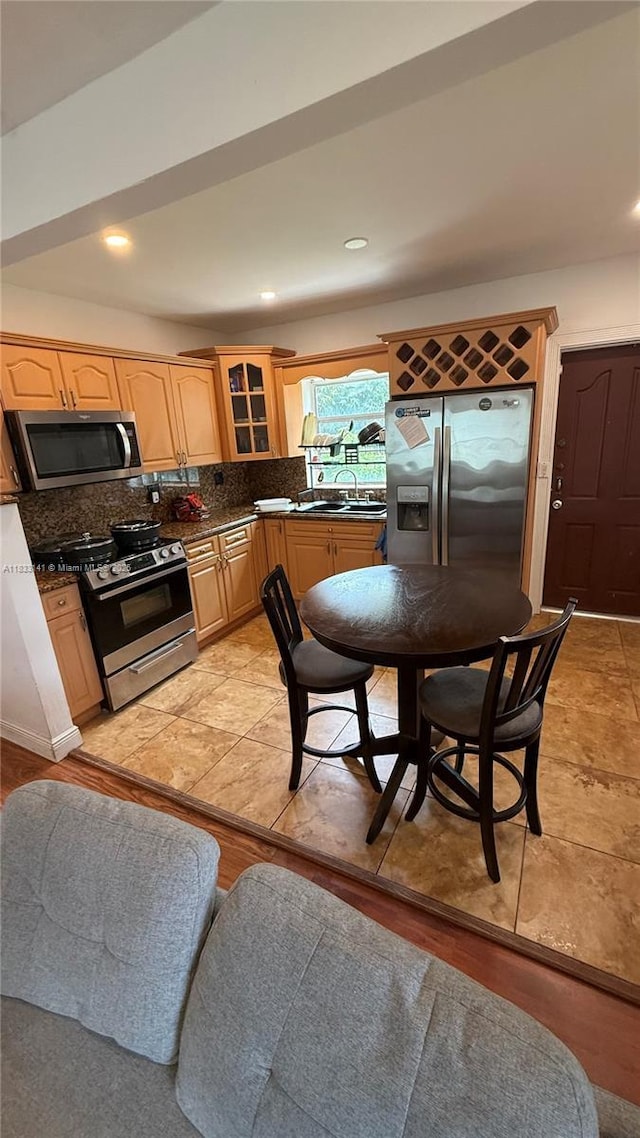 110 SW 64th Ct, Miami, FL 33144 - kitchen with appliances with stainless steel finishes, dark countertops, backsplash, glass insert cabinets, and light brown cabinets