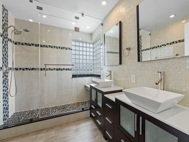171 NW 152nd Ave, Pembroke Pines, FL 33028 - bathroom featuring a stall shower, vanity, tile walls, tasteful backsplash, and wood finished floors