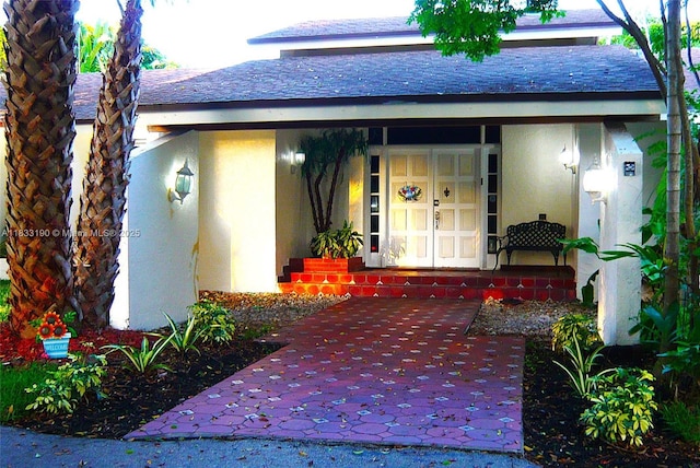 17123 SW 78th Pl, Palmetto Bay, FL 33157 - view of exterior entry featuring stucco siding, a shingled roof, and a porch