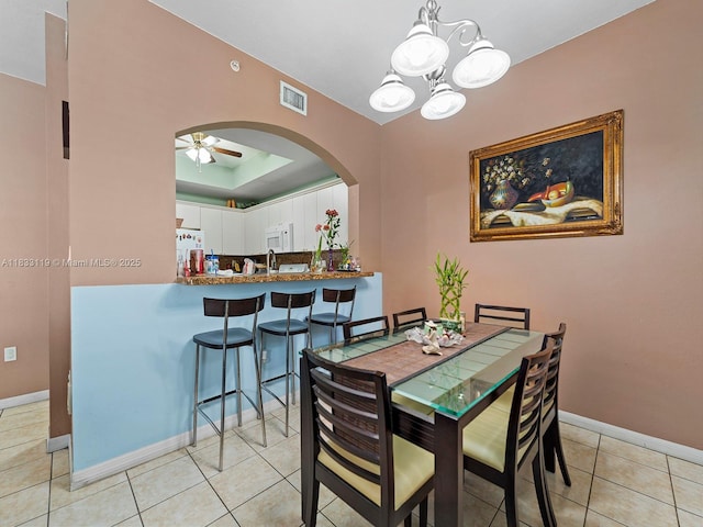 8912 W Flagler St Unit 103, Miami, FL 33174 - dining area with arched walkways, a ceiling fan, light tile patterned flooring, a chandelier, and a tray ceiling