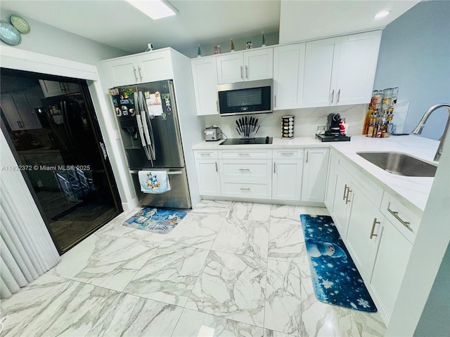 5072 W 12th Ln Unit D-14, Hialeah, FL 33012 - kitchen with stainless steel appliances, white cabinetry, light marble finish flooring, and a peninsula