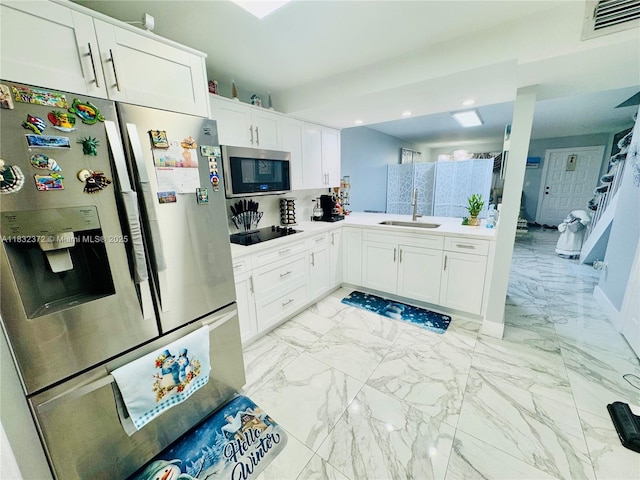 5072 W 12th Ln Unit D-14, Hialeah, FL 33012 - kitchen with stainless steel appliances, white cabinetry, light marble finish floors, light countertops, and recessed lighting