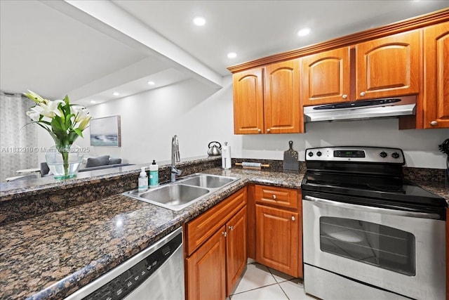 540 Brickell Key Dr Unit 412, Miami, FL 33131 - kitchen with stainless steel appliances, under cabinet range hood, light tile patterned floors, dark stone countertops, and recessed lighting