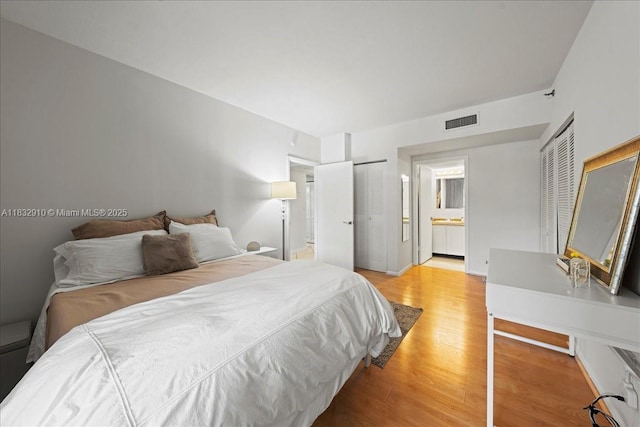 540 Brickell Key Dr Unit 412, Miami, FL 33131 - bedroom with light wood-style floors, connected bathroom, and two closets