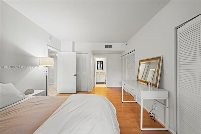540 Brickell Key Dr Unit 412, Miami, FL 33131 - bedroom featuring two closets, wood finished floors, and ensuite bath