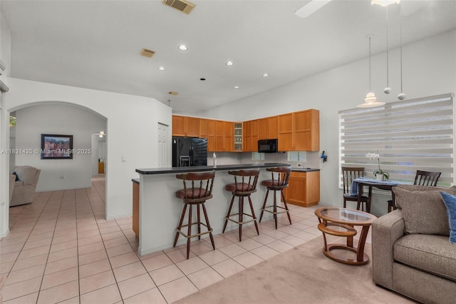 2373 NW 195th Ave, Pembroke Pines, FL 33029 - kitchen featuring black appliances, arched walkways, open floor plan, light tile patterned flooring, and glass insert cabinets