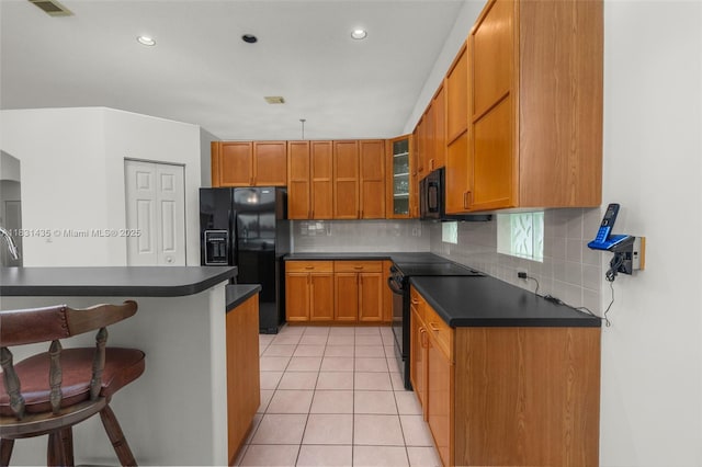 2373 NW 195th Ave, Pembroke Pines, FL 33029 - kitchen featuring black appliances, dark countertops, a breakfast bar, brown cabinetry, and backsplash