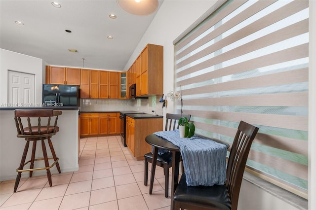 2373 NW 195th Ave, Pembroke Pines, FL 33029 - kitchen featuring black appliances, light tile patterned floors, tasteful backsplash, a breakfast bar, and brown cabinetry