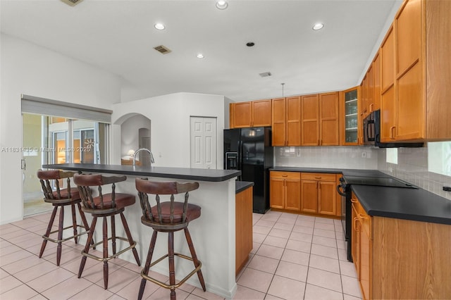 2373 NW 195th Ave, Pembroke Pines, FL 33029 - kitchen with black appliances, dark countertops, tasteful backsplash, a breakfast bar, and recessed lighting