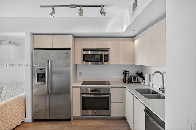 4250 Biscayne Blvd Unit 1206, Miami, FL 33137 - kitchen featuring stainless steel appliances, light countertops, light wood-style flooring, track lighting, and modern cabinets