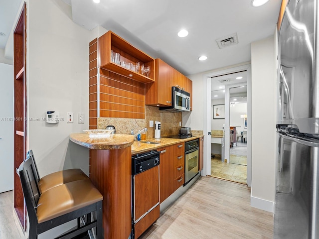 1395 Brickell Ave Unit 3310, Miami, FL 33131 - kitchen with appliances with stainless steel finishes, open shelves, backsplash, light wood finished floors, and recessed lighting