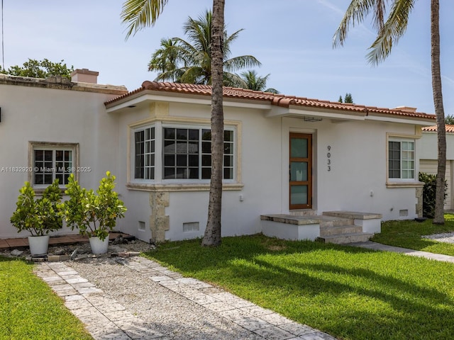 9033 Carlyle Ave, Surfside, FL 33154 - mediterranean / spanish home featuring a front yard, stucco siding, and a tile roof