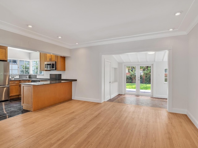 9033 Carlyle Ave, Surfside, FL 33154 - kitchen featuring appliances with stainless steel finishes, hardwood / wood-style flooring, a peninsula, open floor plan, and brown cabinets