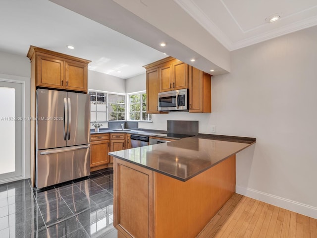 9033 Carlyle Ave, Surfside, FL 33154 - kitchen with stainless steel appliances, a peninsula, brown cabinets, crown molding, and recessed lighting