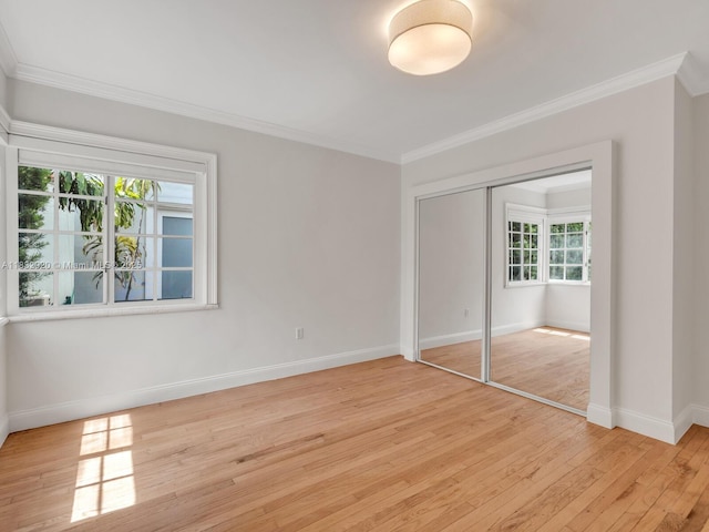 9033 Carlyle Ave, Surfside, FL 33154 - unfurnished bedroom with light wood-style flooring, ornamental molding, and a closet
