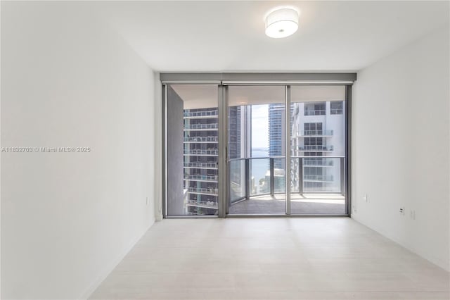 1000 Brickell Plz Unit 3703, Miami, FL 33131 - unfurnished room with a wall of windows and baseboards