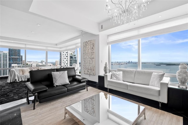1425 Brickell Ave Unit 42E, Miami, FL 33131 - living room with a chandelier, a view of city, a tray ceiling, recessed lighting, and a water view