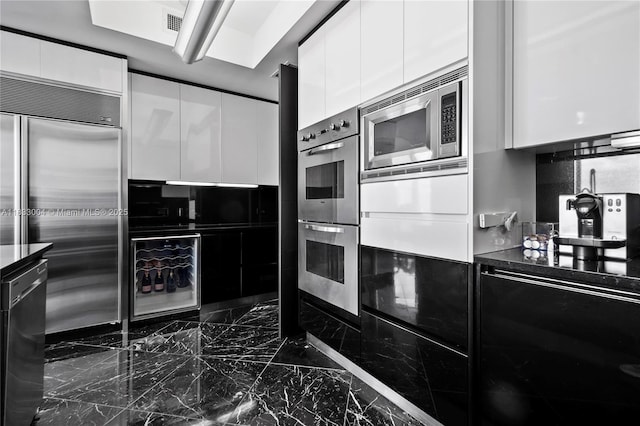 1425 Brickell Ave Unit 42E, Miami, FL 33131 - kitchen featuring modern cabinets, built in appliances, white cabinets, dark countertops, and dark marble finish flooring
