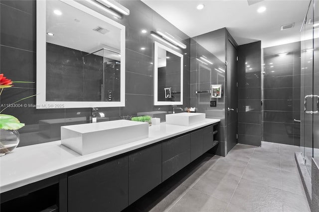 1425 Brickell Ave Unit 42E, Miami, FL 33131 - full bathroom featuring tile walls, double vanity, a stall shower, recessed lighting, and tile patterned floors