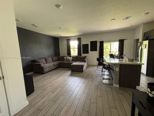 830 SE 19th St, Homestead, FL 33034 - living area with wood finished floors, plenty of natural light, and a textured ceiling
