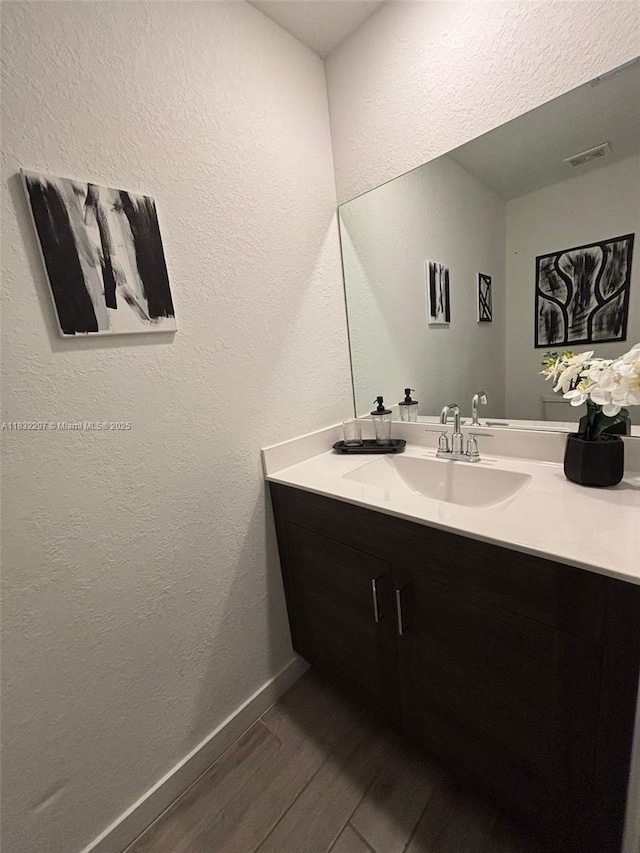 830 SE 19th St, Homestead, FL 33034 - bathroom featuring wood finished floors, vanity, and a textured wall