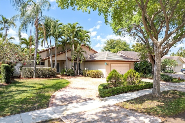 14460 Glencairn Rd, Miami Lakes, FL 33016 - view of front of home with an attached garage, stucco siding, driveway, and a front yard