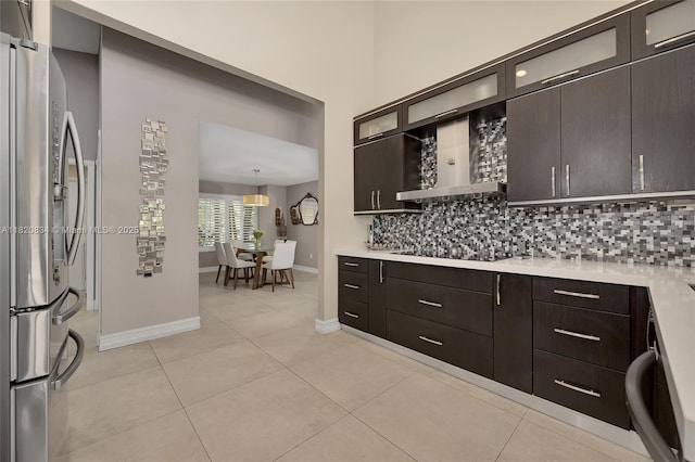 14460 Glencairn Rd, Miami Lakes, FL 33016 - kitchen featuring freestanding refrigerator, black electric cooktop, decorative backsplash, light countertops, and dark brown cabinets