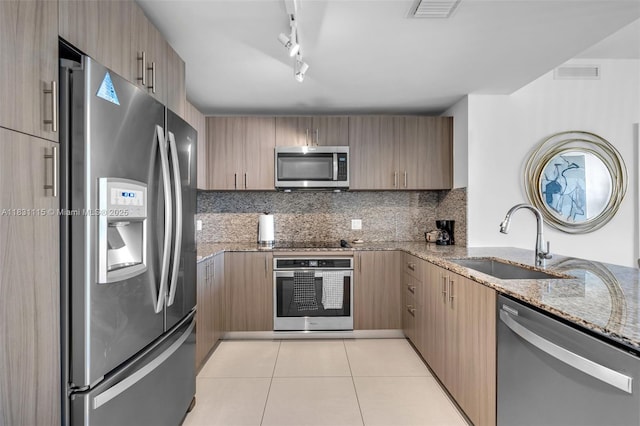 5350 NW 84th Ave Unit 1513, Doral, FL 33166 - kitchen with stainless steel appliances, light stone countertops, light tile patterned floors, backsplash, and rail lighting